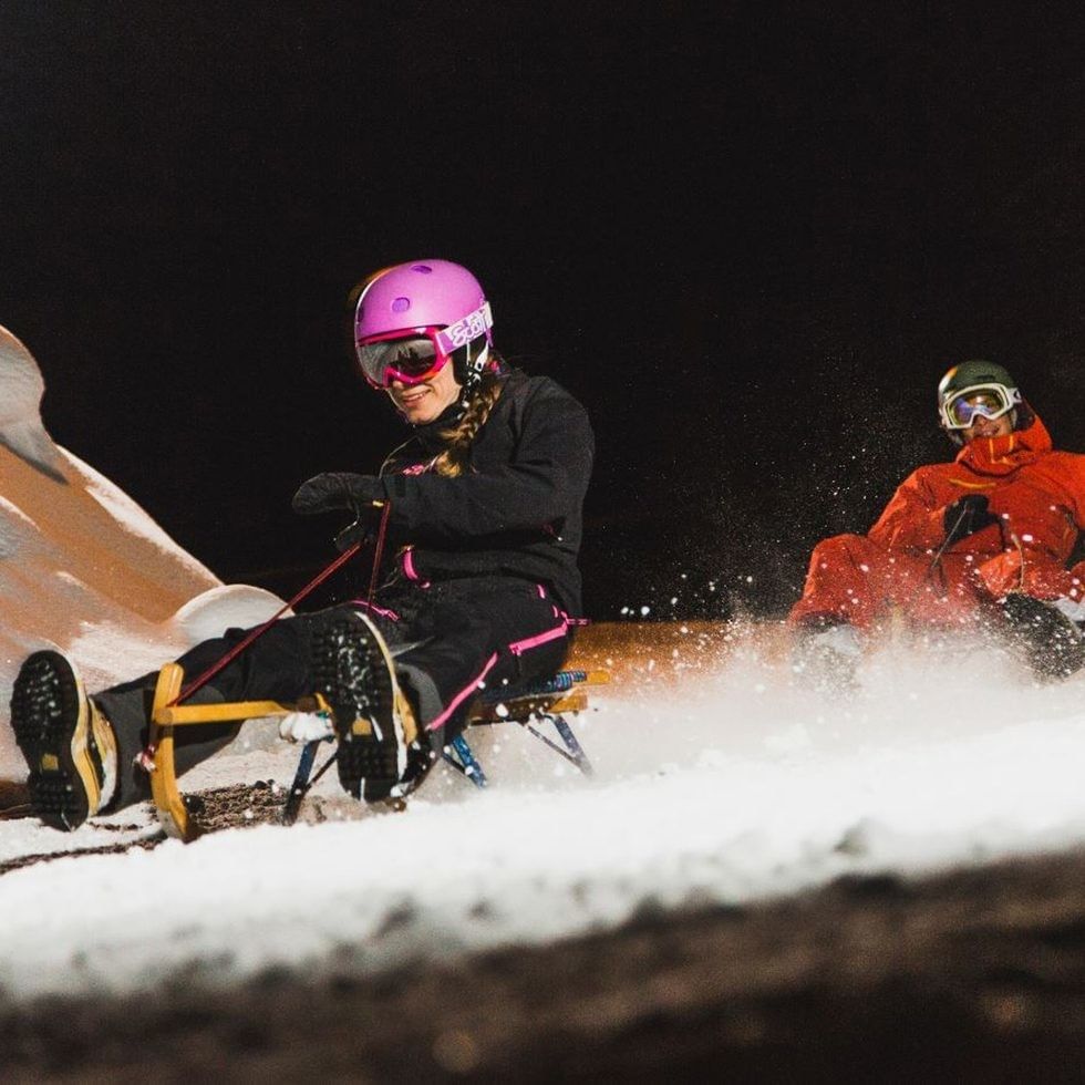 Zwei Personen auf einem Schlitten bei Nacht in Schladming.