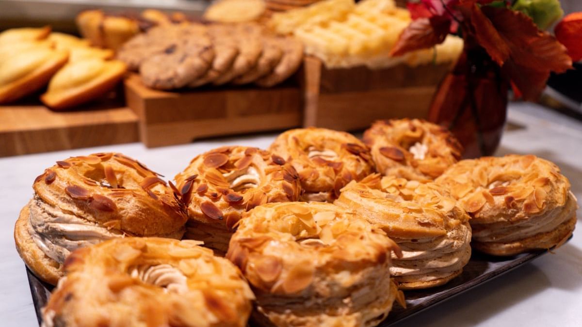 Assorted pastries on a platter with cookies and waffles on a table in Restaurant Le W at Warwick Paris Champs Elysées