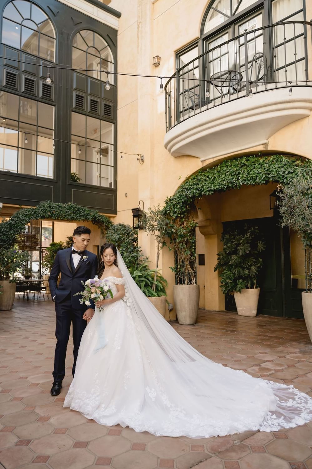 Beautiful bride and groom pose in the charming outdoor courtyard at El Prado Hotel