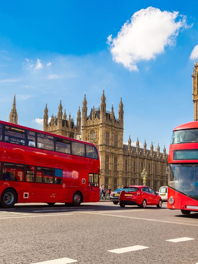 Red double-decker buses by Big Ben and the Houses of Parliament near Warwick Hotels & Resort