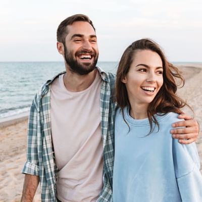 A couple walking on the beach near Hôtel de l'Europe