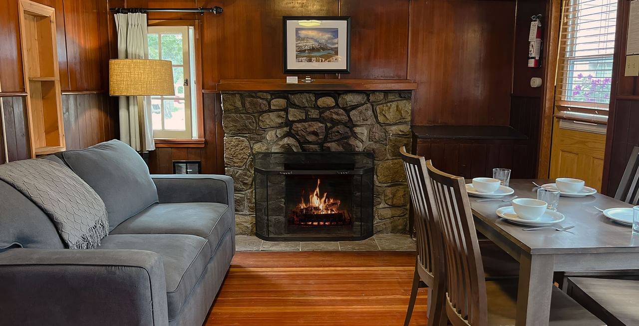Interior of cabin with dining area, couch, and fireplace