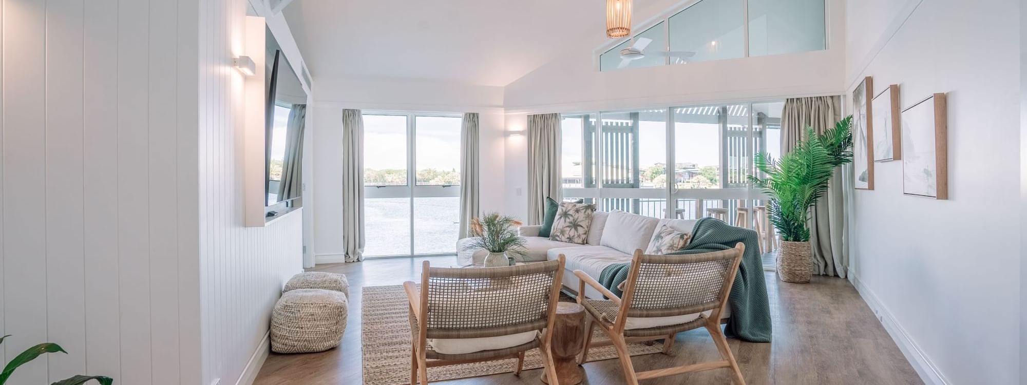 TV lounge area with plush seating by the window and wooden floors at Novotel Sunshine Coast Resort