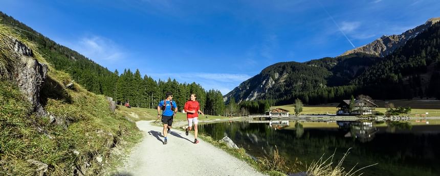 Two men are running on the road with mountain view  in Tannheime