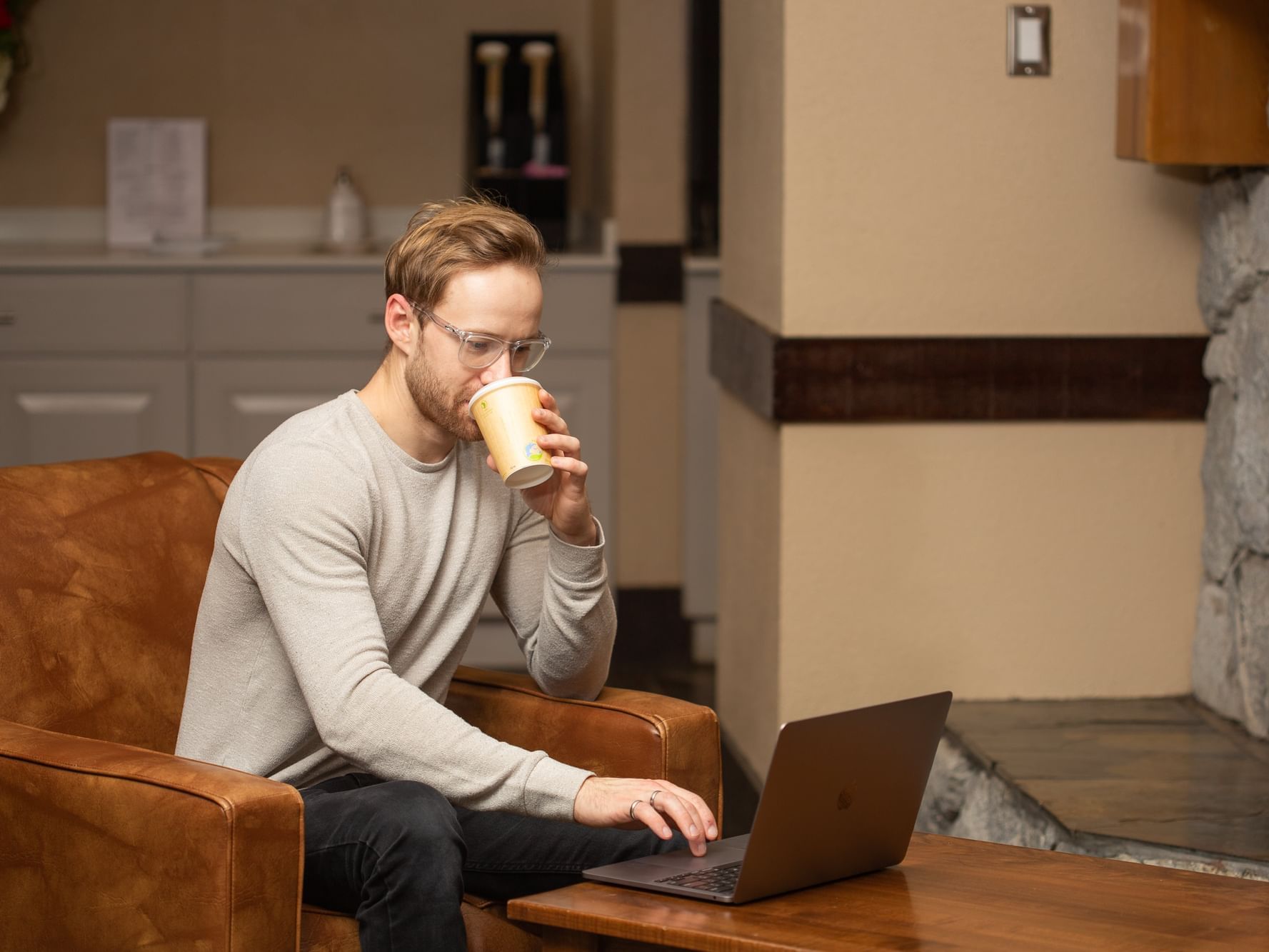 A man working on his laptop while enjoying a coffee at Blackcomb Springs Suites