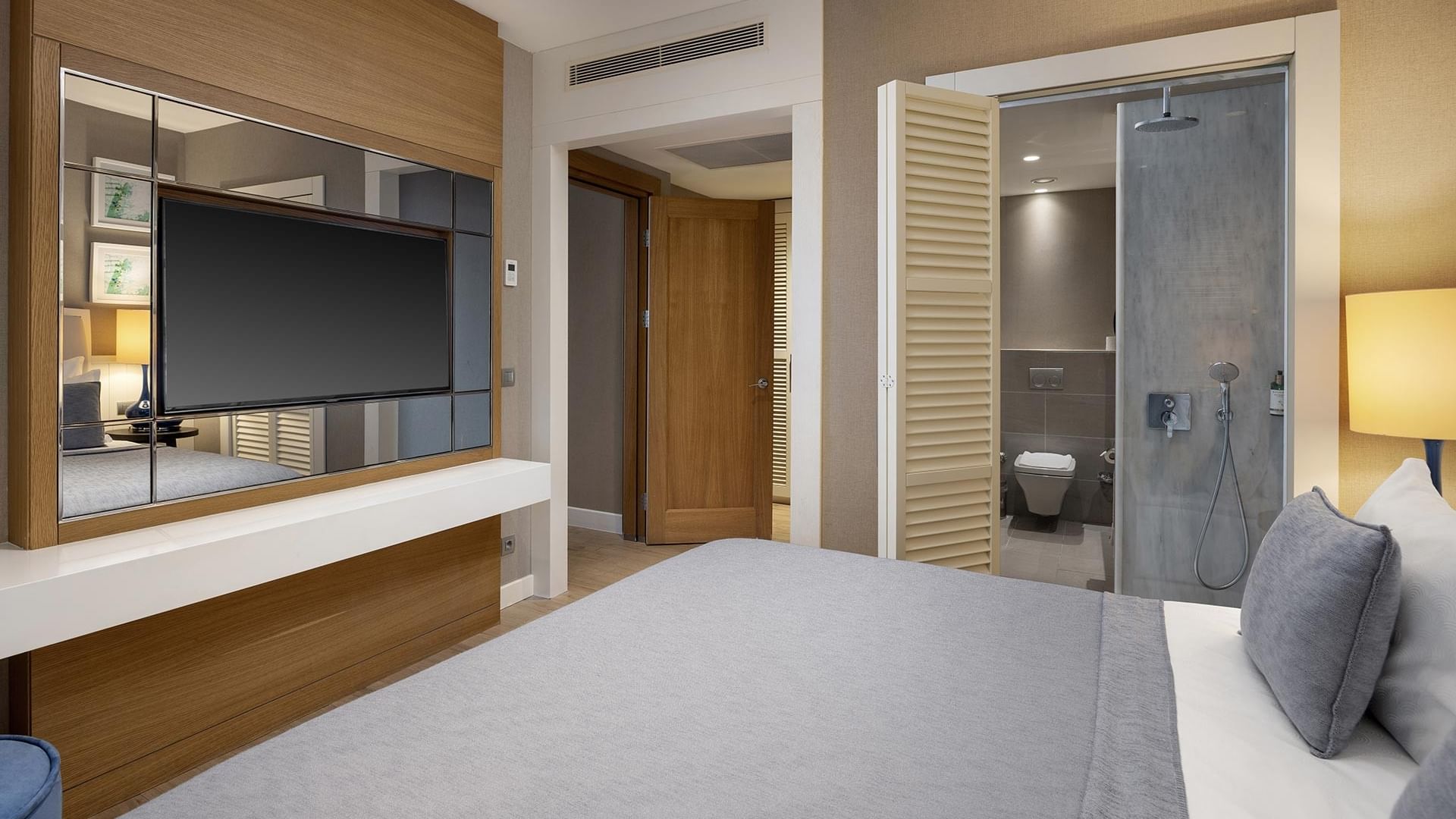 Titanic Luxury Collection Bodrum’da büyük yatak, TV ve aynalı Family Suite.