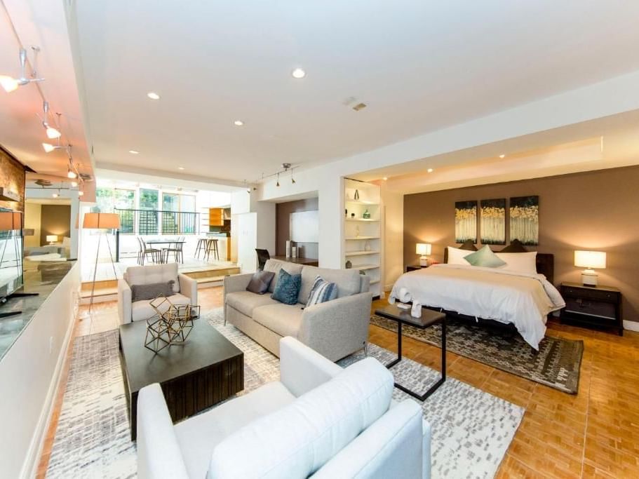 Modern living space with a large bed, couch, and coffee table at Chelsea Pines Inn in New York.