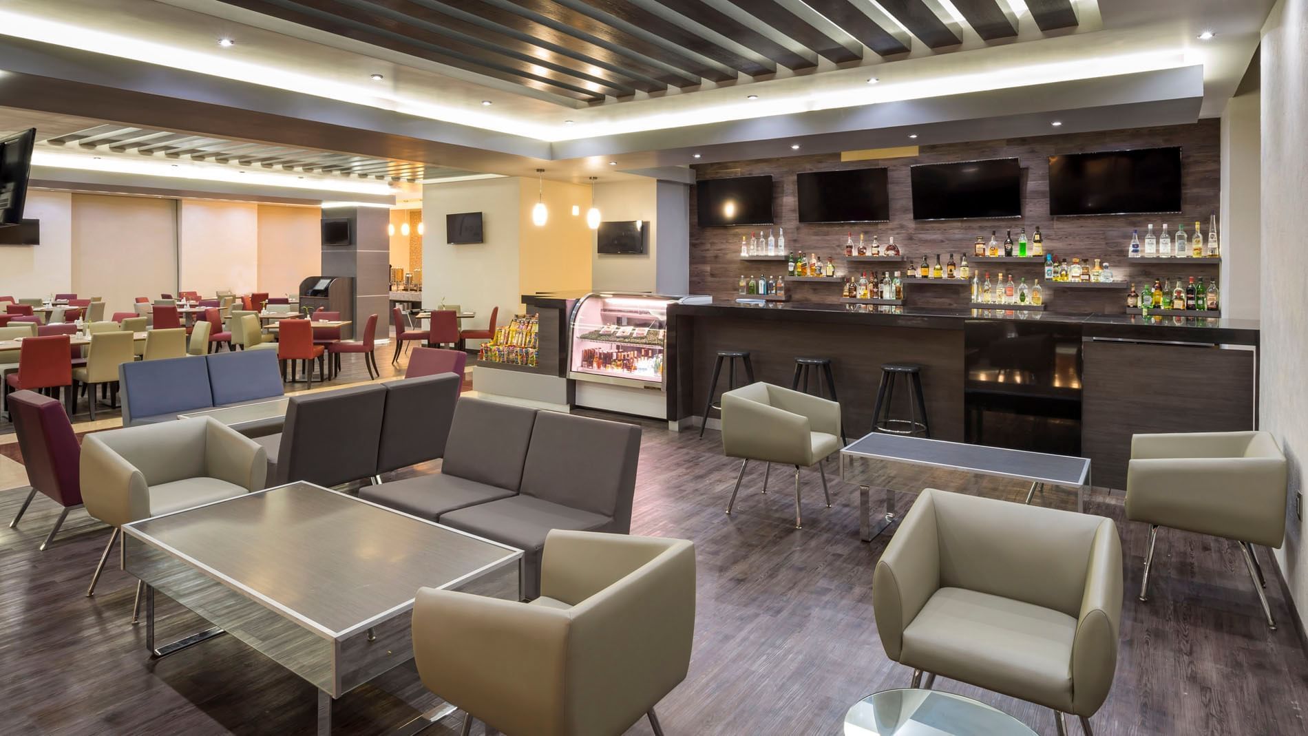 Bar counter by the sleek brown and beige seating with low tables in the Lobby Bar at Real Inn San Luis Potosi