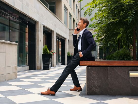 A man on a call while sitting on a bench at ReStays Ottawa