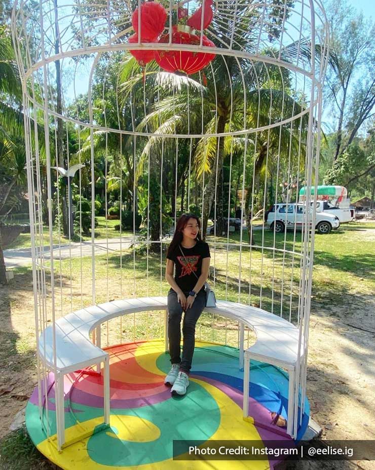 A lady was seated inside a birdcage-like structure that included a rainbow effect on the ground - Lexis Suites Penang