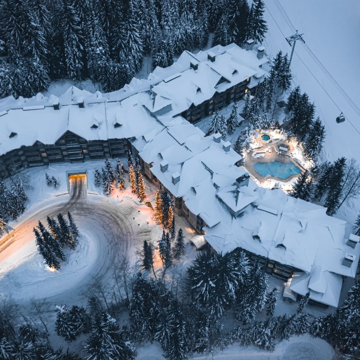 High-angle view of Blackcomb Springs Suites & outdoor pool with snow