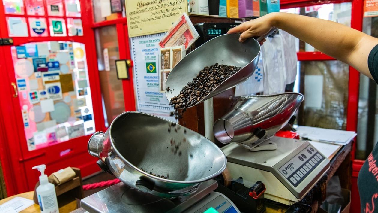 Man measuring coffee beans in shop near The Clermont Hotels