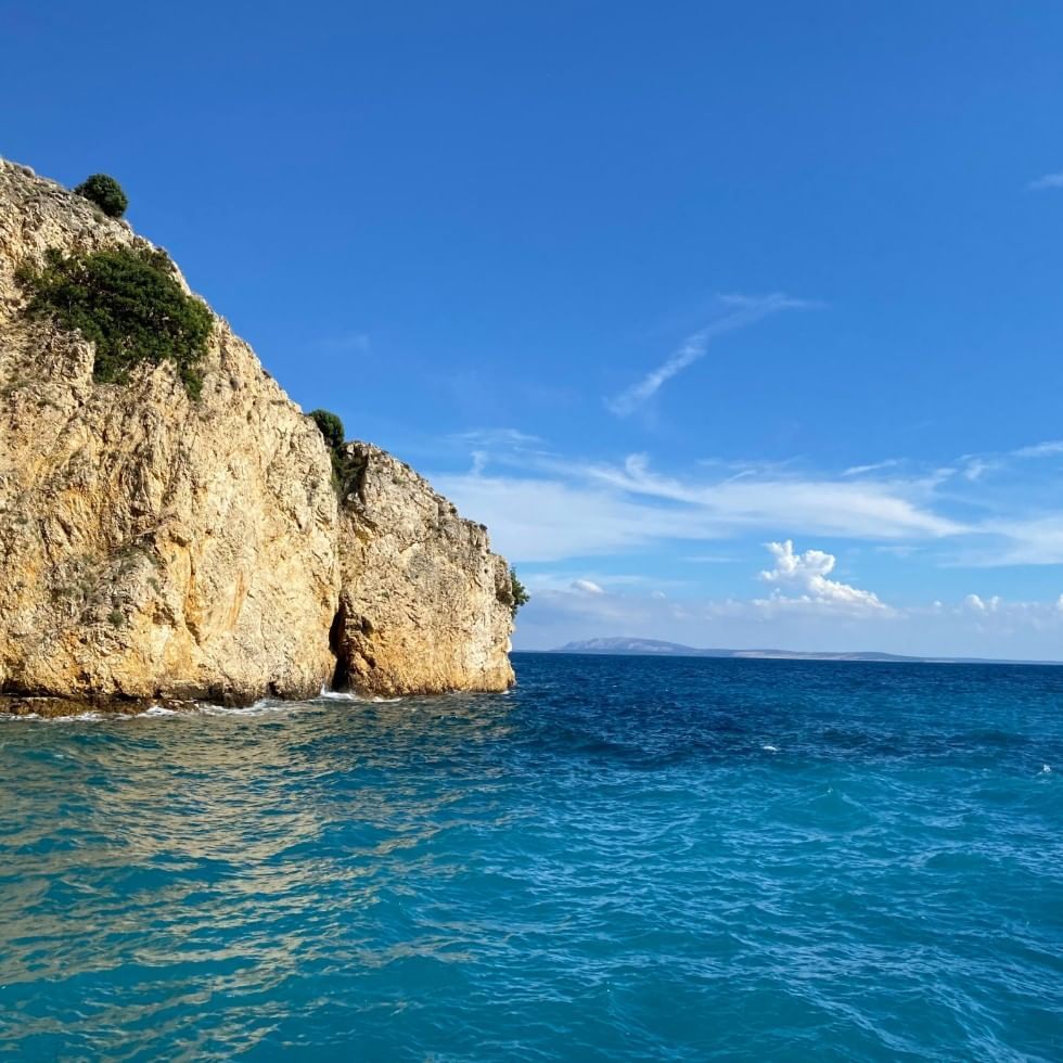 A rock in Baska Sea on a sunny day near Falkensteiner Hotels