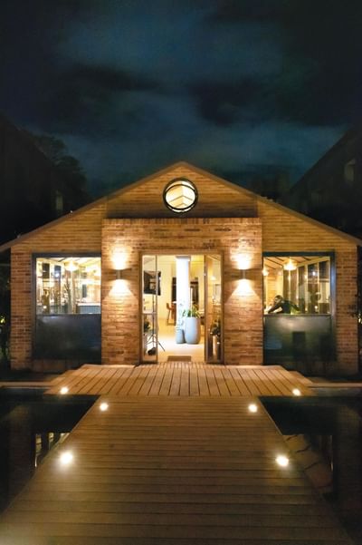 Manduka Restaurant's dining cabin at Habitel Prime Hotel with a wooden deck and cozy nighttime ambiance