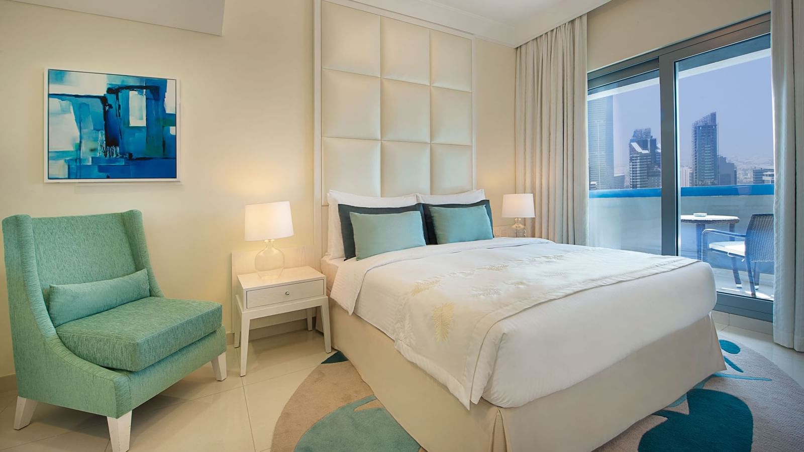 Bed with nightstands and city view in One Bedroom Suite, one of the hotel rooms at DAMAC Maison Mall Street