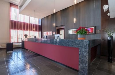 Front desk in reception with computers at Sandman Signature Winnipeg Airport Hotel
