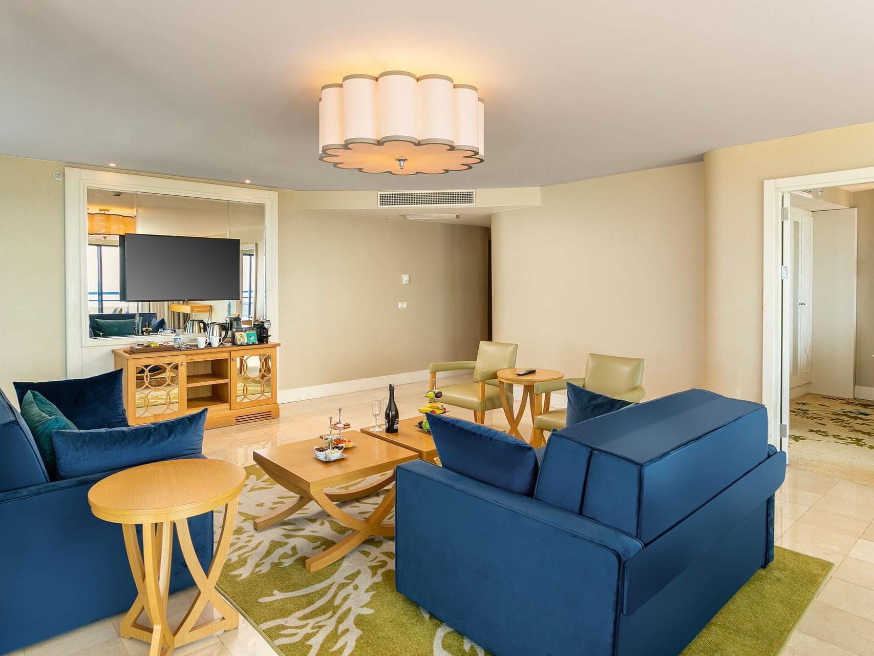 Luxurious living room with blue sofas, light wood tables, and beige walls in Colonel Suite at Titanic Deluxe Lara