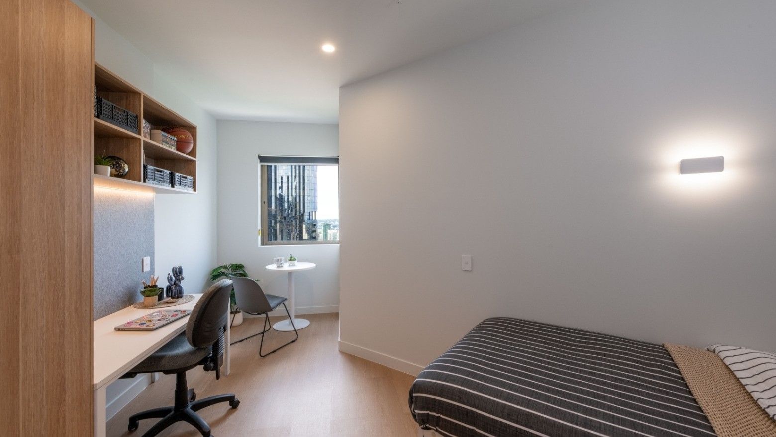 A cozy bedroom with desk, chair, and bed at UniLodge Brisbane City.