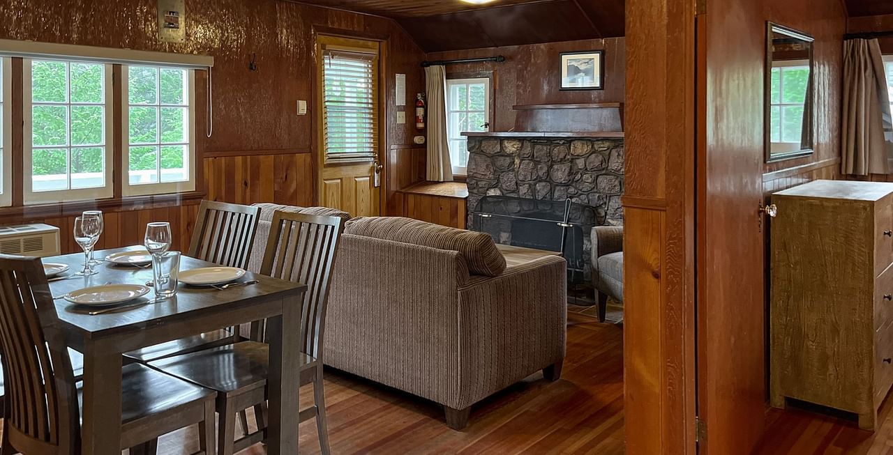 Interior of cabin with dining area, sitting area, and fireplace