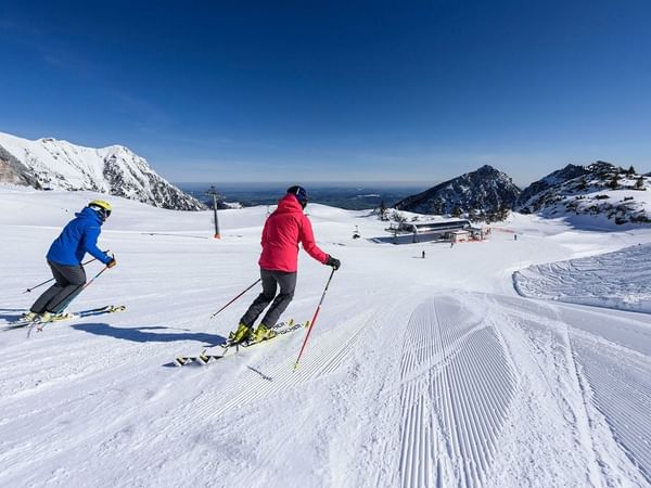 Posterior view of two skiers skiing near Liebes Rot Flueh