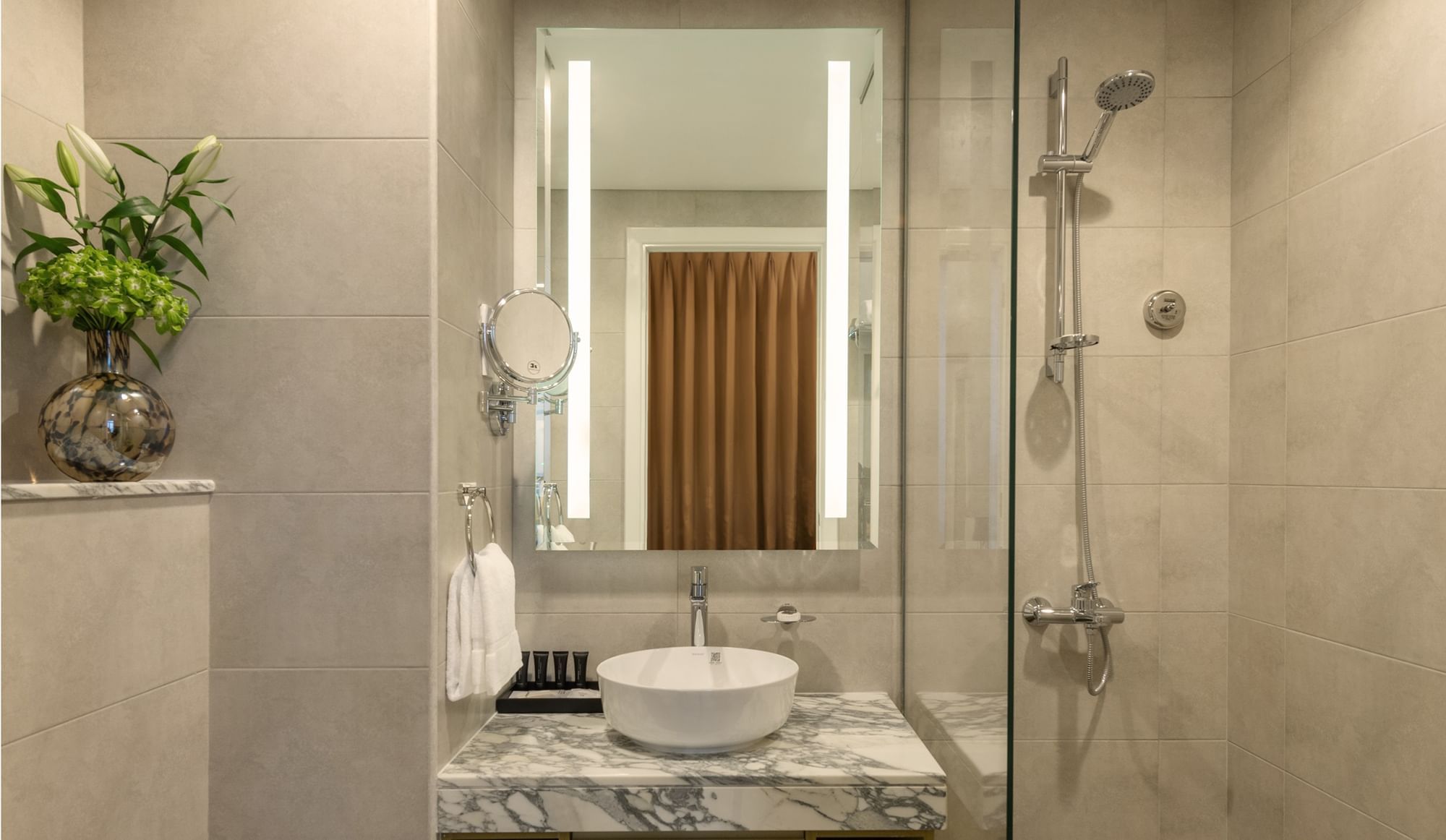 Bathroom shower by the marbled vanity in Studio Apartments at DAMAC Maison Aykon City