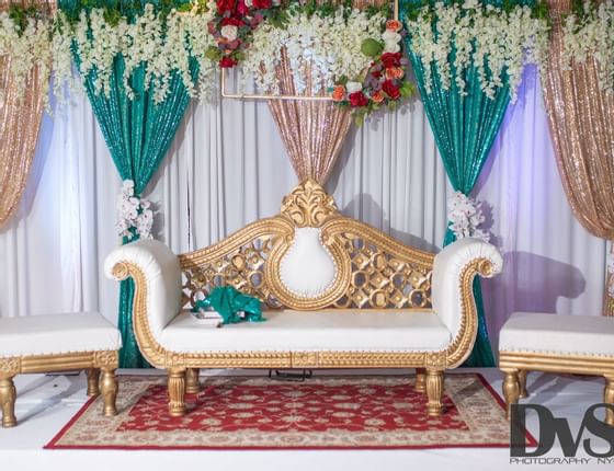 white and gold seating bench with flower wall/curtain décor