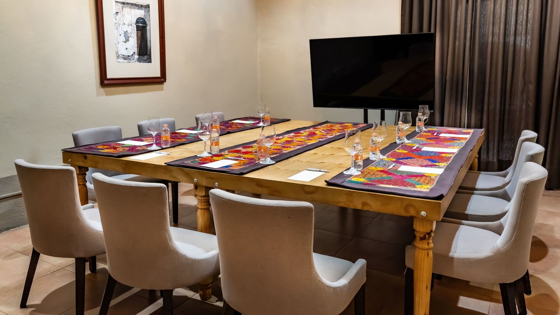 Mesa larga con sillas y televisión en sala de eventos en Quinta Real Puebla Heroica Puebla de Zaragoza.