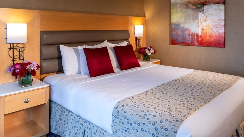 Cozy room with a large bed, two nightstands with lamps, and an abstract painting on the wall at Warwick Hotels and Resorts