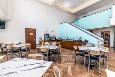 Dining area with marble tables, wooden chairs, and a coffee station by the lobby at Off Shore Resort
