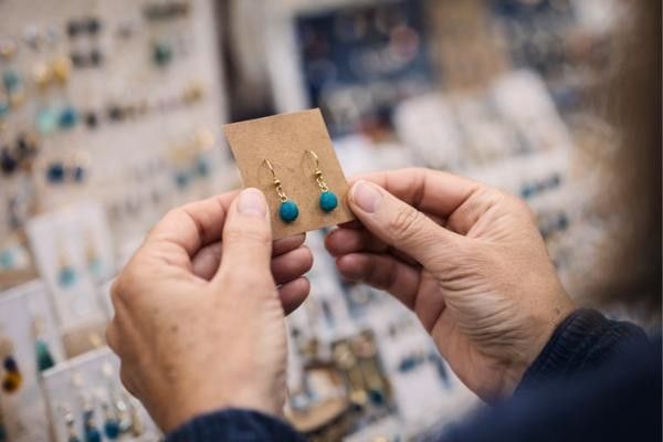 Women looking at pair of earrings at one of the stalls at Godalming Spring Festival