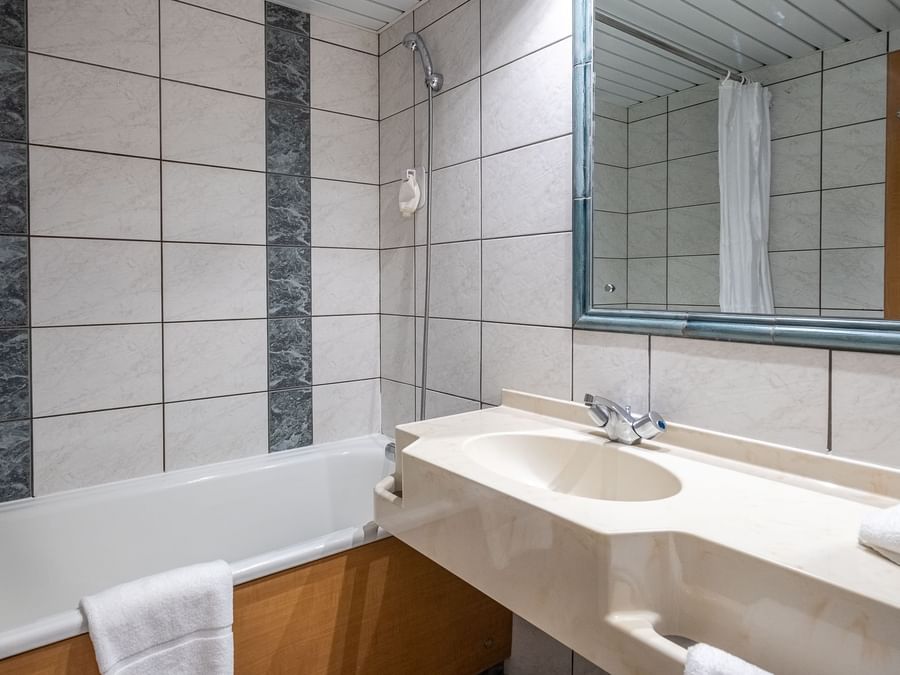 Vanity & bathtub in bathroom of a room at The Originals Hotels