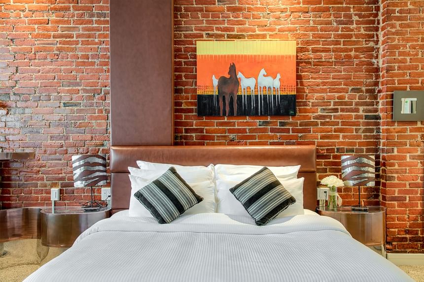 a king bed in front of an exposed brick wall in southwest suite