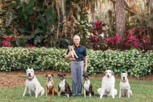 A man with dogs posing in the garden at Rosen Inn Universal