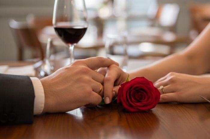 Couple holding hands inside restaurant at Gorse Hill in Surrey for their valentines day meal