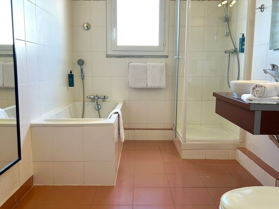 Bathroom with bathtub, separate shower, and toilet at Hôtel Cap Maya in Agde.