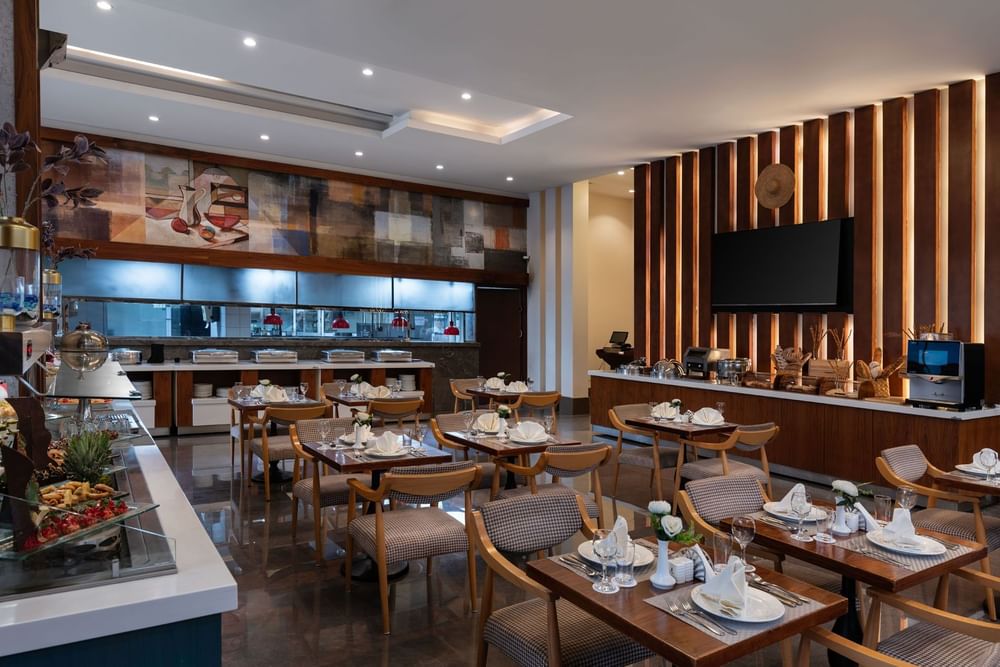 Seasons Restaurant dining area with elegant wooden furniture and patterned chairs at Warwick Hotel Jeddah