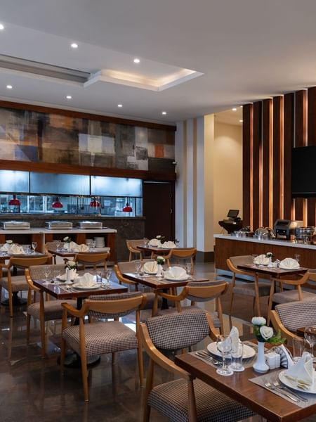 Seasons Restaurant dining area with elegant wooden furniture and patterned chairs at Warwick Hotel Jeddah