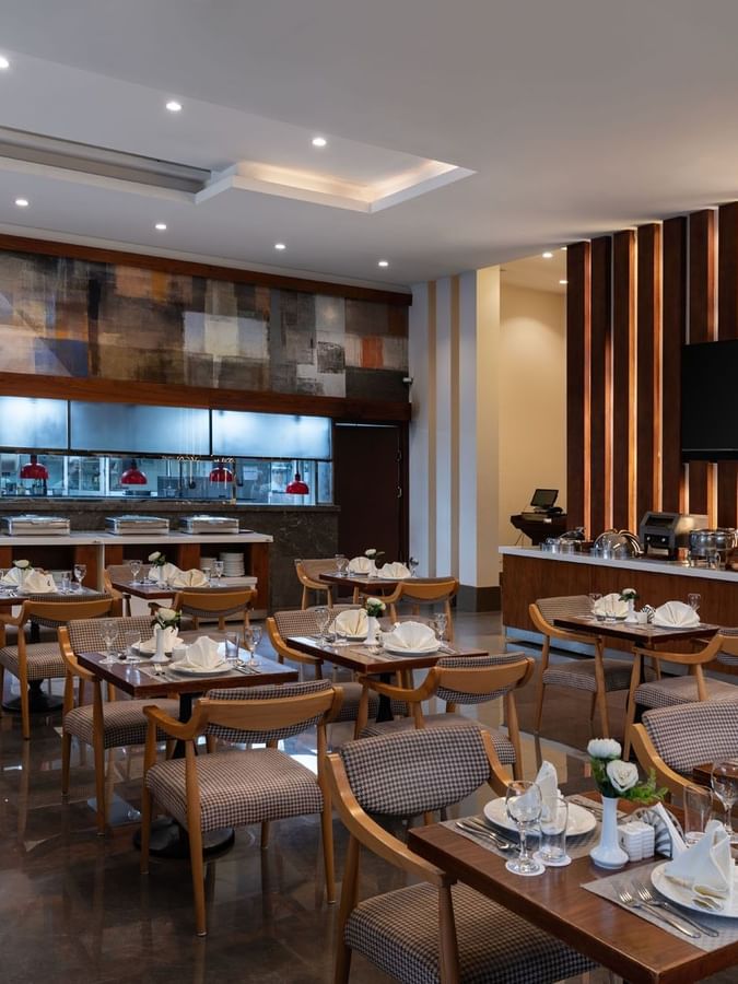 Seasons Restaurant dining area with elegant wooden furniture and patterned chairs at Warwick Hotel Jeddah