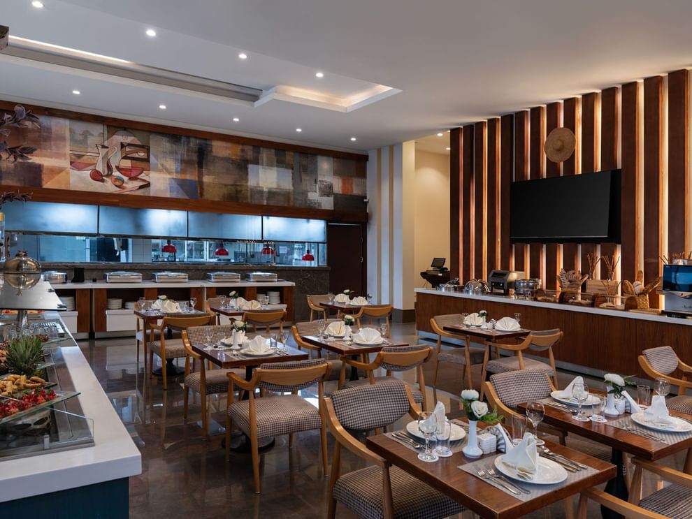 Seasons Restaurant dining area with elegant wooden furniture and patterned chairs at Warwick Hotel Jeddah