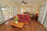 Living room with patio doors to private balcony at Waimea Plantation Cottages 