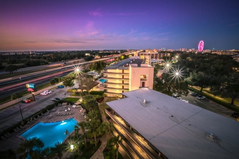 An ariel view of Rosen Inn at Pointe Orlando surrounded by a nighttime cityscape.