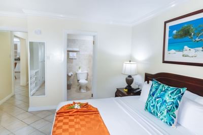 Croton Superior Double Room with a bed, lamp, and bathroom visible through an open door at Bay Gardens Hotel