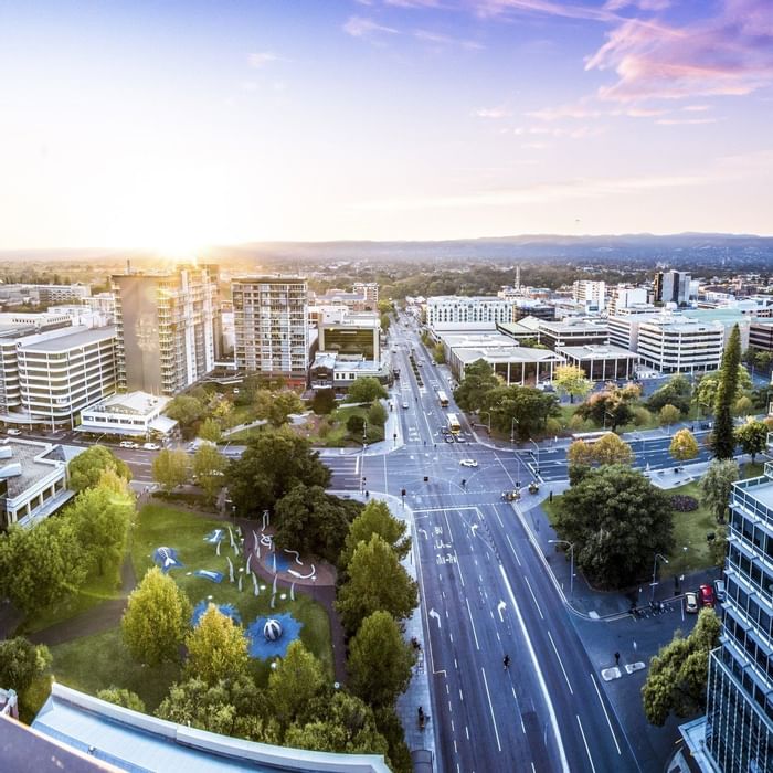 Panoramic view of the cityscape with urban buildings, busy roads, and a green park near Ibis Adelaide