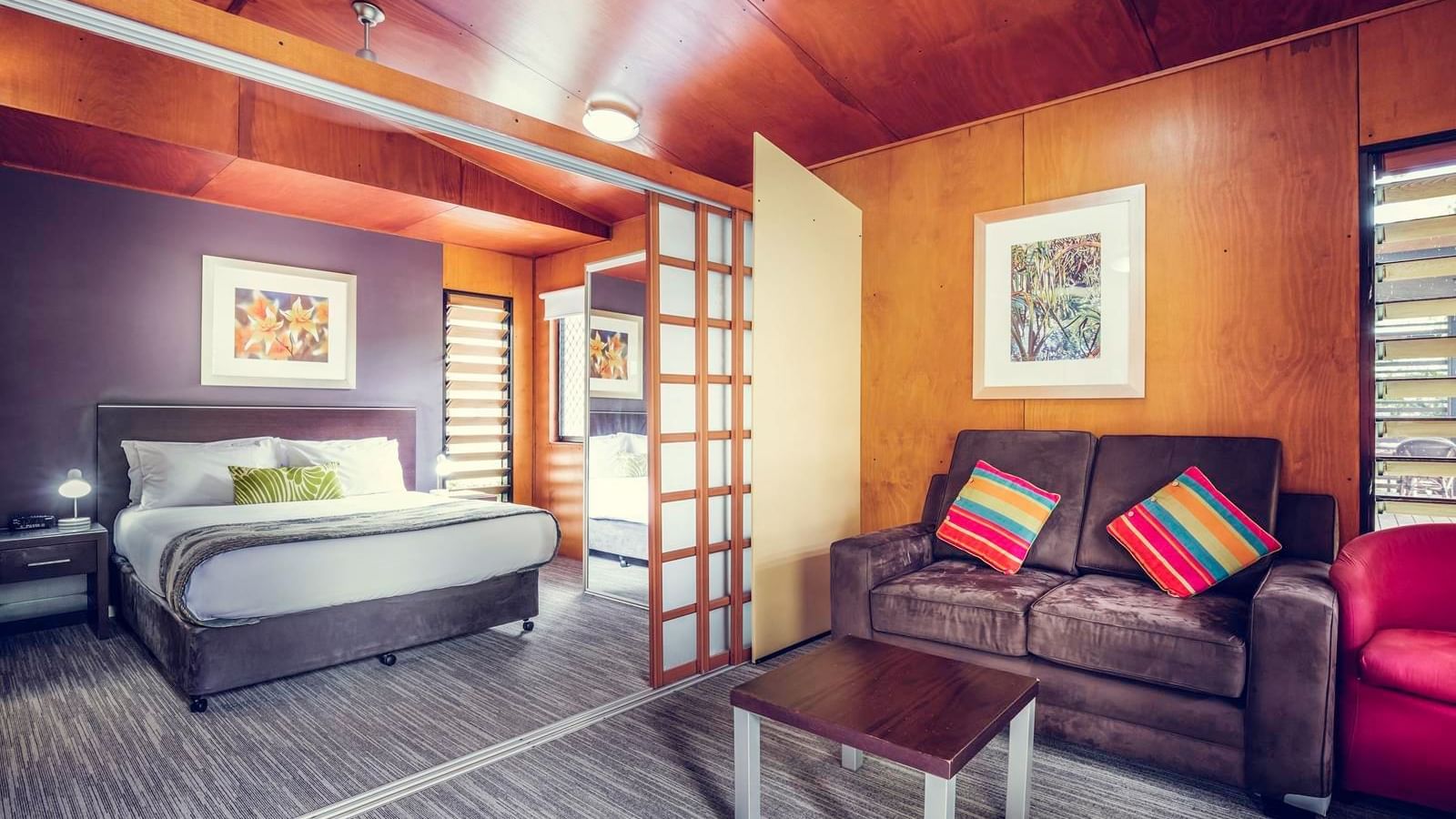 Living area & king bed in a room at Darwin Airport Hotels