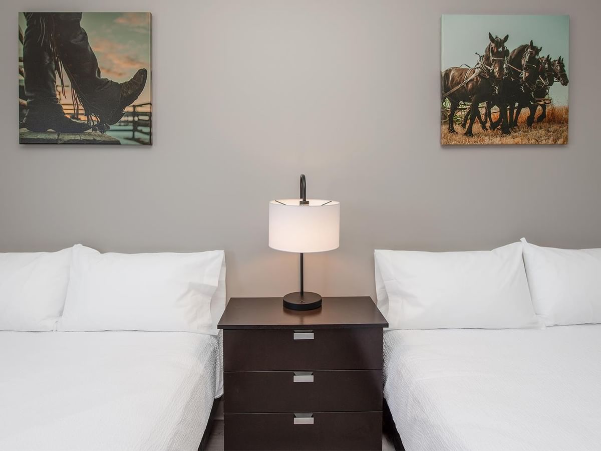Two beds and artwork on walls at Coast Innisfail Hotel.