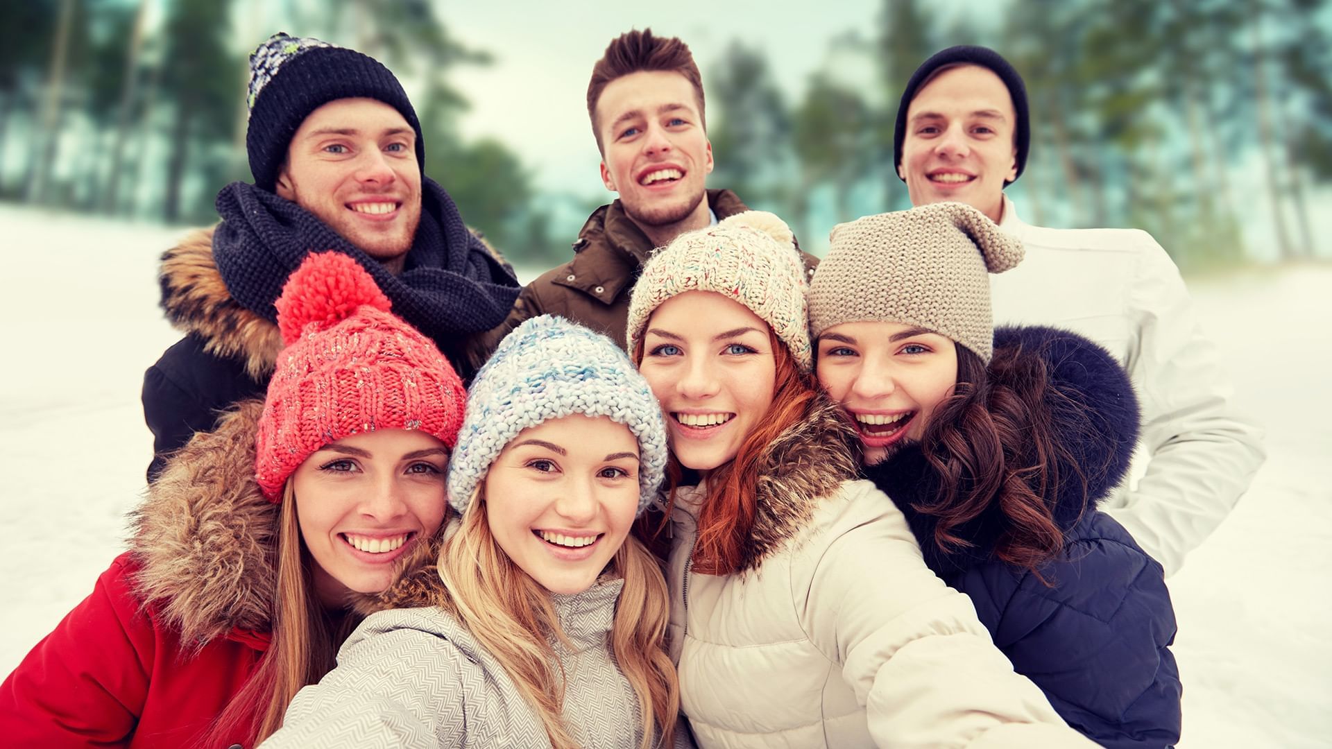 Group of people in winter clothing taking a selfie in a snowy landscape at Listel Whistler, a Coast Hotel