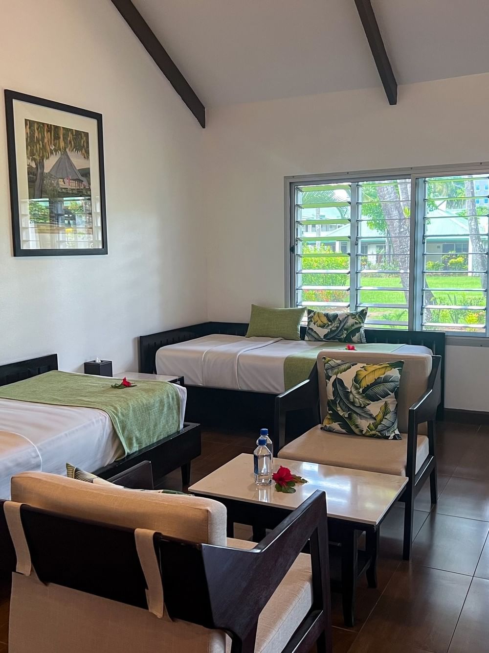 Twin beds with green runners by armchairs and framed art in One Bedroom Villa at TokaToka Resort Nadi Fiji
