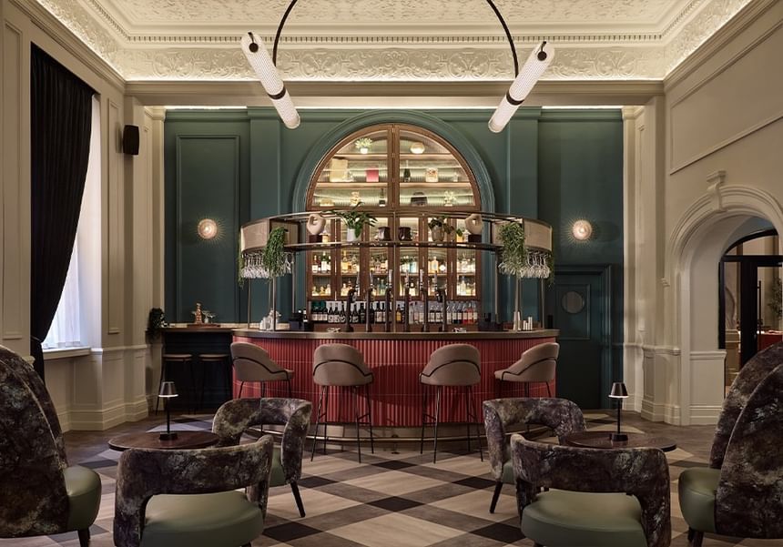 Elegant Gott\'s Bar with plush seating and arched shelving, featuring exposed bottles at The Met Hotel Leeds, England