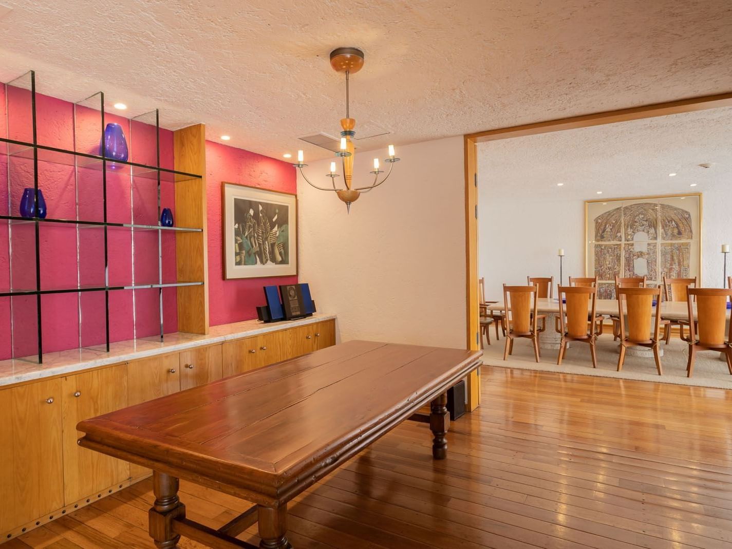 King Presidential Suite dining room with wooden tables and a striking pink accent wall at Camino Real Polanco Mexico