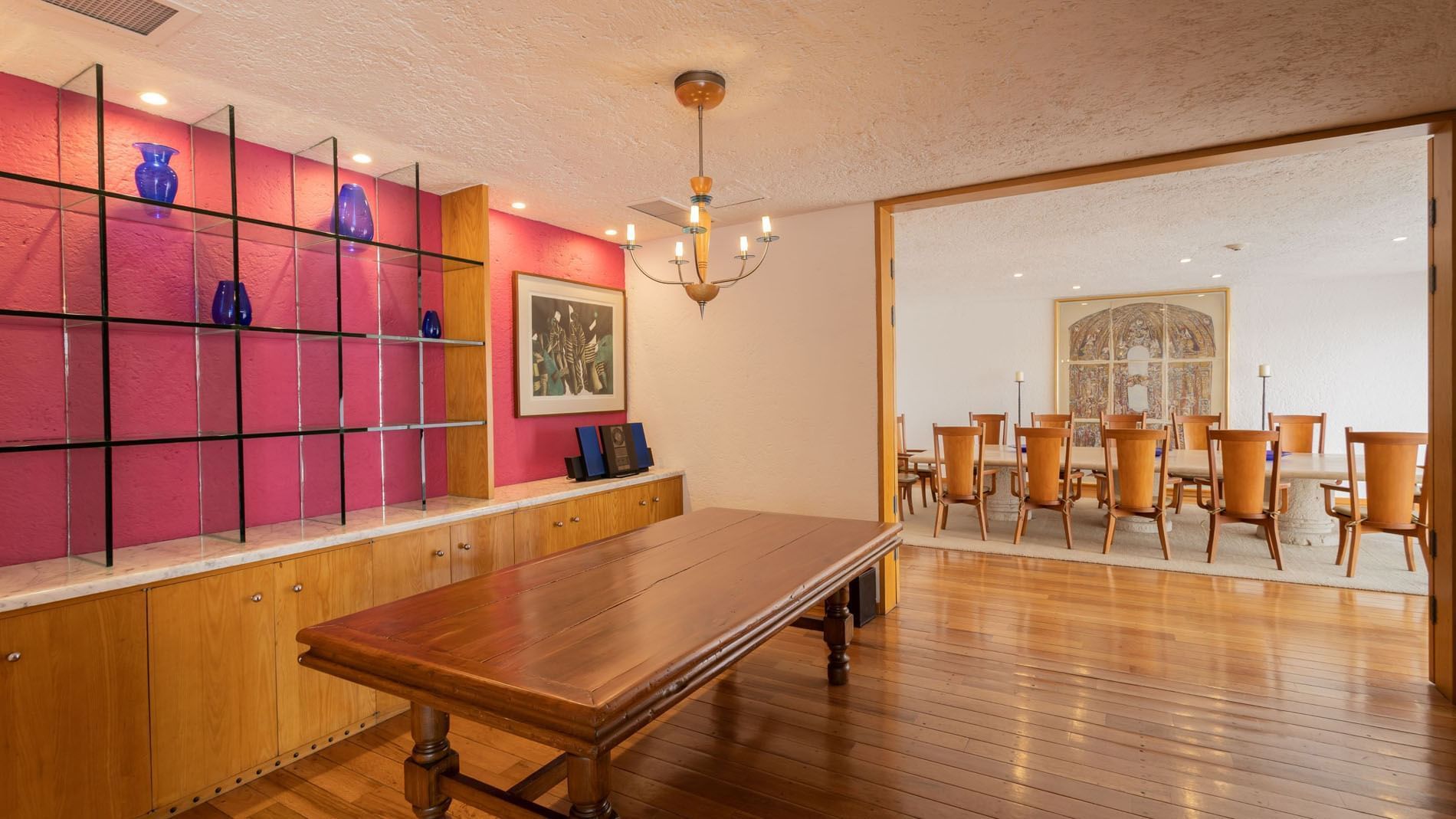 King Presidential Suite dining room with wooden tables and a striking pink accent wall at Camino Real Polanco Mexico